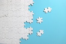 Plain Blue Background With Disassemble Incomplete White Jigsaw Puzzle For Your Background Or Your Content.