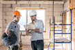 © puhimec - Two builders collaborate to build a new home.