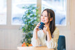© buritora - カフェでホットドリンクを飲んでくつろぐ女性
