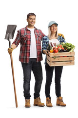 Canvas Print - Full length portrait of a male farmer holding a shovel and a female farmer holding a crate with vegetables