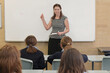 Primary school female teacher teaching math in classroom