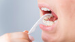 © Михаил Решетников - Caucasian woman brushing teeth with toothpick with dental floss on white background.