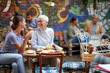 © luckybusiness - two females, different ages, sitting in outdoor cafe, talking, smiling, drinking coffee, looking each other.