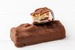 Two chocolate ice cream bars with caramel and peanuts on white background close up macro shot