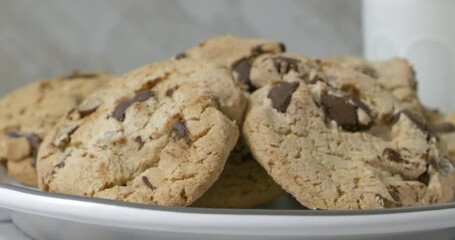 Sticker - Closeup of a hand taking a chocolate chip cookie from a plate slow motion
