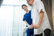 © Kawee - Asian female therapist helping senior male patient to practice walking