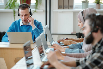 Wall Mural - Young contact center employee working with customers complaints