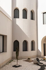 modern east style building with windows and sunlight shadows on beige walls. abstract minimal archit