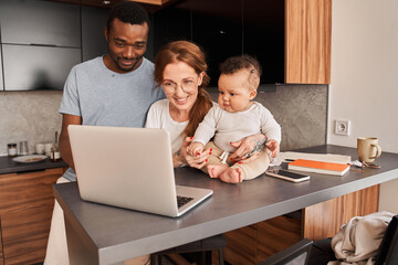 Wall Mural - Man looking at the laptop screen with his wife while she sitting