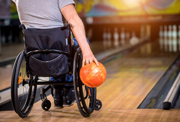 Two young disabled men in wheelchairs playing bowling in the club