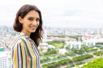 Happy beauty Caucasian young woman with high building and cityscape background Attractive beautiful girl has nice smile Get relax, enjoy life with happiness Lovely lady portrait She look at camera