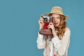 Wall Mural - curly blonde woman holding retro vintage photo camera,