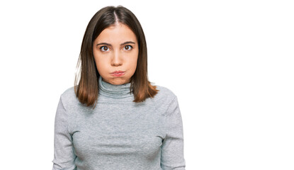 Canvas Print - Young beautiful woman wearing casual turtleneck sweater puffing cheeks with funny face. mouth inflated with air, crazy expression.