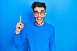© Krakenimages.com - Young hispanic man wearing casual clothes and glasses pointing finger up with successful idea. exited and happy. number one.