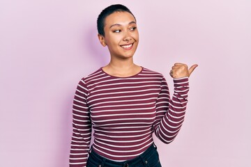 Sticker - Beautiful hispanic woman with short hair wearing casual striped sweater pointing thumb up to the side smiling happy with open mouth