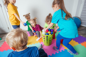 Wall Mural - Sporty kids enjoying activities with young teacher