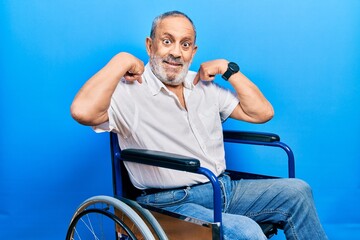 Sticker - Handsome senior man with beard sitting on wheelchair looking confident with smile on face, pointing oneself with fingers proud and happy.