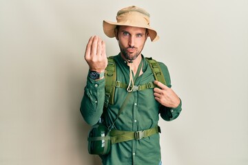 Poster - Handsome man with beard wearing explorer hat and backpack doing italian gesture with hand and fingers confident expression