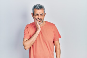 Sticker - Handsome middle age man with grey hair wearing casual t shirt touching mouth with hand with painful expression because of toothache or dental illness on teeth. dentist