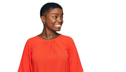 Sticker - Young african american woman wearing casual clothes looking away to side with smile on face, natural expression. laughing confident.