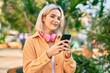 © Krakenimages.com - Young blonde girl smiling happy using smartphone and headphones at the park.