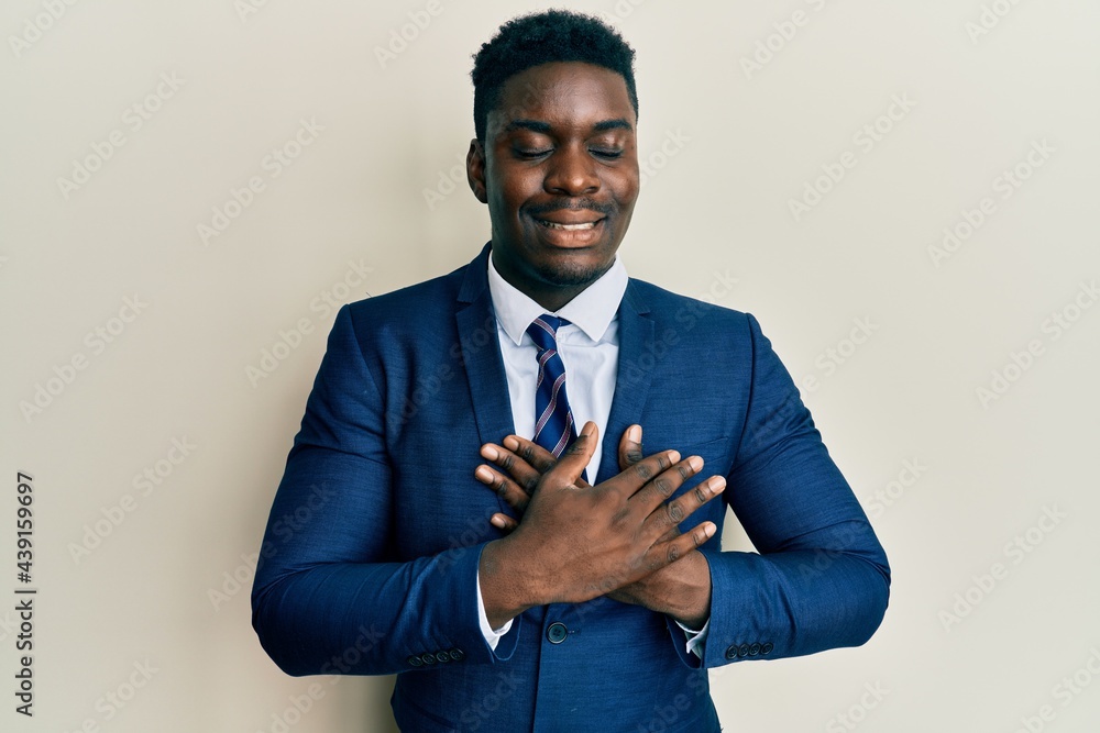 Handsome black man wearing business suit and tie smiling with hands on ...