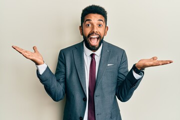 Canvas Print - Handsome hispanic man with beard wearing business suit and tie celebrating crazy and amazed for success with arms raised and open eyes screaming excited. winner concept