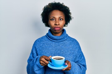 Sticker - Young african american woman drinking a cup of coffee relaxed with serious expression on face. simple and natural looking at the camera.