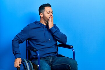 Sticker - Handsome hispanic man with beard sitting on wheelchair bored yawning tired covering mouth with hand. restless and sleepiness.