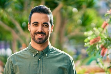 Young hispanic man smiling happy standing at the park.