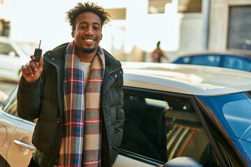 Young african american man smiling happy holding key car at the city