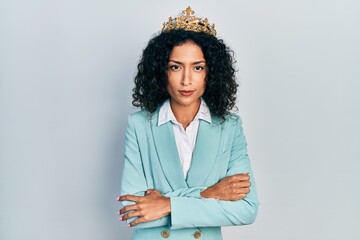 Young latin girl wearing business clothes and queen crown skeptic and nervous, disapproving expression on face with crossed arms. negative person.