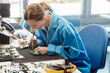 © Kzenon - Worker in electronics manufacturing soldering a component