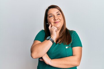 Wall Mural - Beautiful brunette plus size woman wearing casual clothes thinking concentrated about doubt with finger on chin and looking up wondering