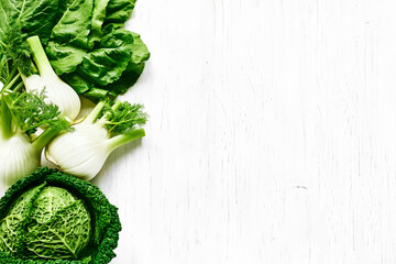 Poster - Fresh Florence fennel bulbs and savoy cabbage on white wooden background. Raw organic spring vegetables top view. Genuine healthy eating.