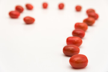 Fresh cherry tomato in row on white background