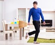 © Elnur - Young man cleaning floor with broom