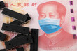 Microchips shortage in China because of COVID-19 pandemic. Concept. Picture of computer chips placed on banknote with applied anti virus face mask (applied by digital montage).