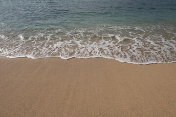 Beach with golden sand, turquoise ocean water. Panoramic sea view. Natural background for summer vacation.