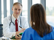 © Bangkok Click Studio - Focusing to caucasian doctor carrying stethoscope talking and explaining. Doctor suggesting to woman patient by look at laptop in examination room at hospital