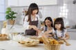 © Bangkok Click Studio - Beautiful Asian mother teaching two young daughters how to make a bakery in a modern kitchen. Idea for love and relationship of a family at home.