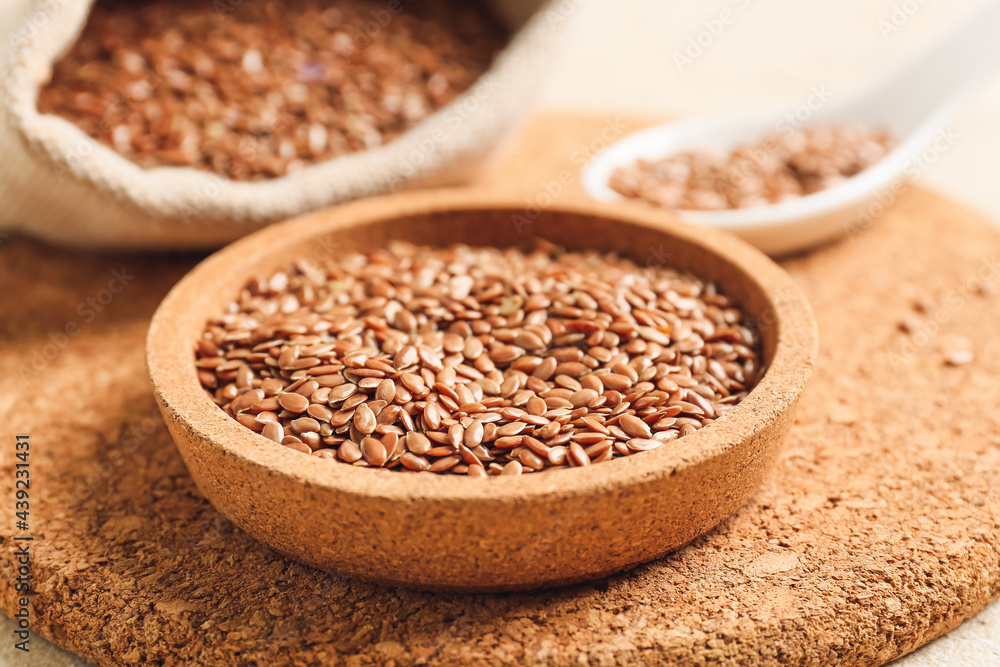 Bowl with flax seeds on table, closeup