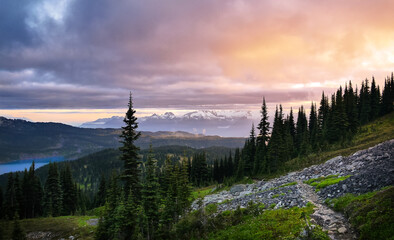 Wall Mural - Glacial mountain Garibaldi lake at sunset. View of a mountain lake between fir trees. Mountain peaks above the lake lit by sunset rays. Garibaldi Provincial Park. Canada