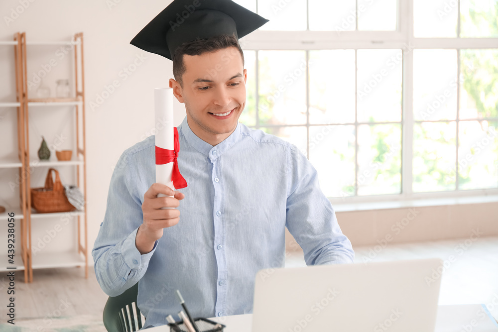 Happy male student on his graduation day at home. Concept of online education