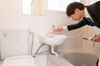 住宅リフォーム　バスルームの水栓を調査するビジネスマン