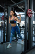 © nazarovsergey - Woman doing reverse lunges on Smith machine at gym