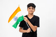 Young Indian boy proudly holds the tricolour Indian flag. Teenager holding national flag