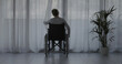 © StockPhotoPro - Woman in wheelchair at home alone