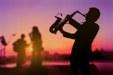 Silhouette Twilight Scene Of Saxophone Man Showing As Trio Musicians. Background For Celebrate Party Or Autumn And Summer Festival.