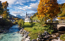 Beautiful Nature Landscape. Incredible Autumn Scenery. View On Alpine Highlands With Rock Mountains, Colorful Trees And Small Church On The River Bank.view On Famous Parish Church Of St. Sebastian